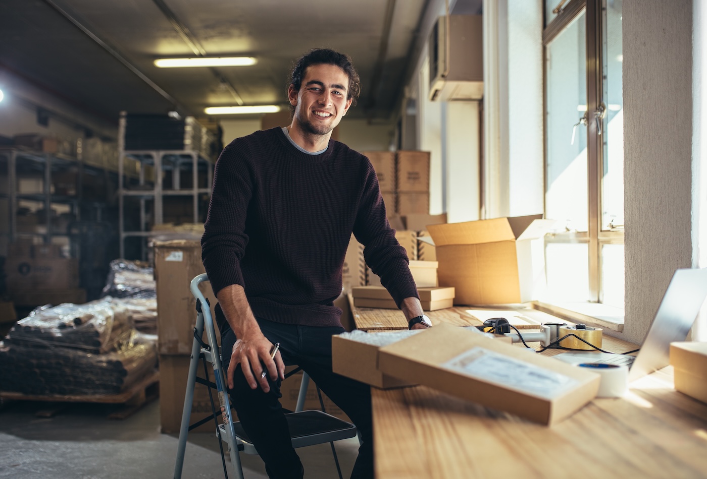 Confident young businessman working at online business store. Small business owner at his work desk.